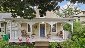 A two-story house with a porch, a blue door, and a number '245' on the wall. - Elegant Linden Hills Home, Family Friendly, Walk to Lake, Dining, and Shopping (Minneapolis)