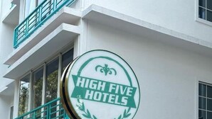 A sign for High Five Hotels with a white building in the background. - High Five Hotels (Assagao)