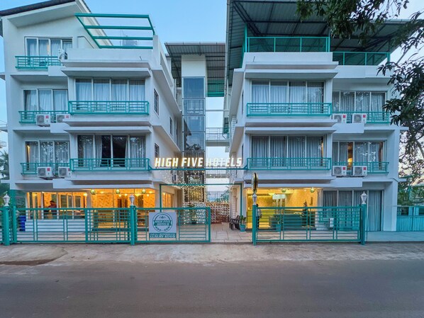 A hotel with multiple balconies, a sign reading 'HIGH FIVE HOTELS', and a gated entrance. - High Five Hotels (Assagao)