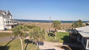Una zona residenziale con una casa grande, un edificio più piccolo e una spiaggia sullo sfondo.