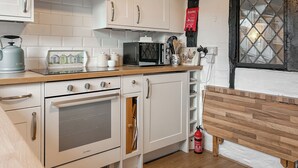 A modern kitchen with white cabinetry, a built-in oven, a microwave, and a gas stove. - 1 bedroom accommodation in Aston Cantlow, near Stratford-upon-Avon (Aston Cantlow, near Stratford-upon-Avon)