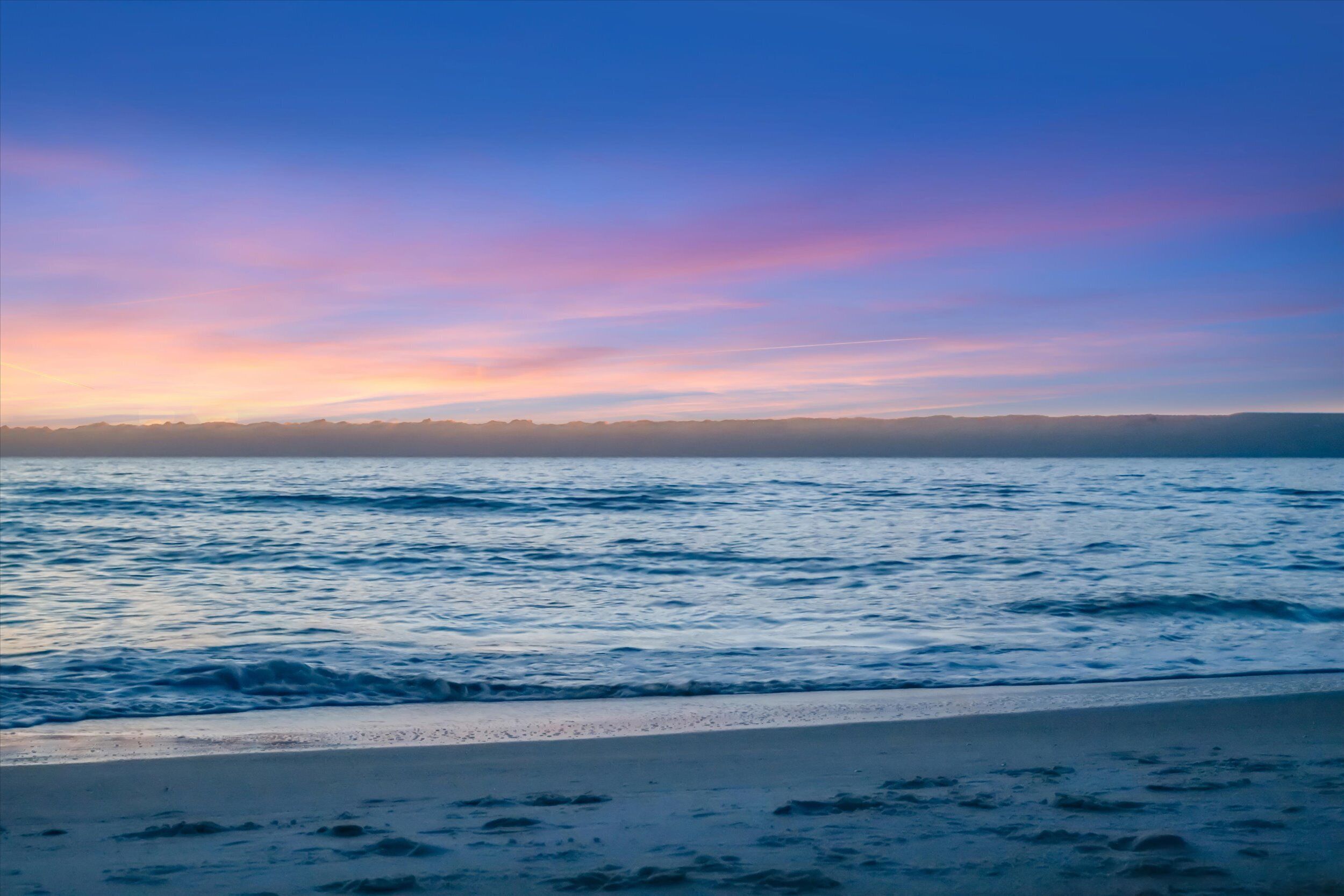 Une plage avec des vagues et un ciel dégagé.