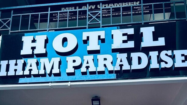 The entrance to Hotel Sham Paradise with a red carpet and potted plants in front. - HOTEL IHAM PARADISE (Mangaluru)