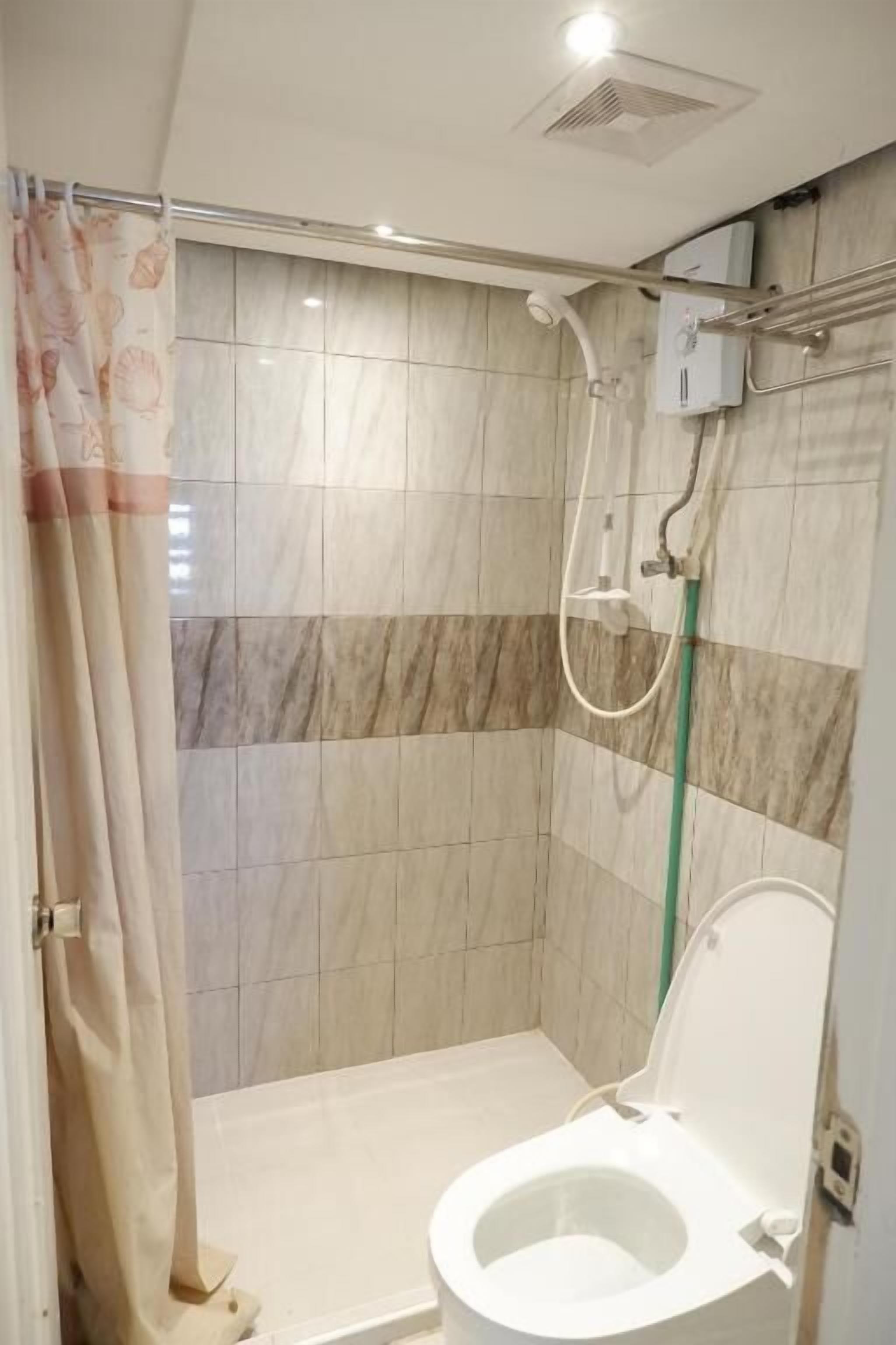 Ein Badezimmer mit Dusche, Toilette und Handtuchhalter.