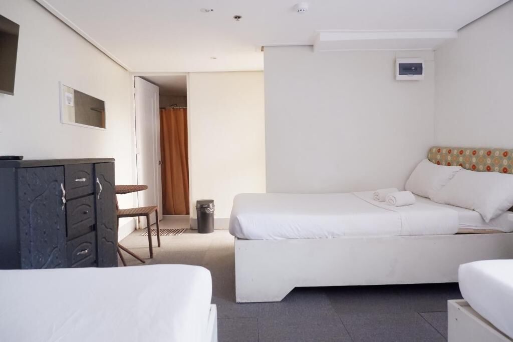 Una habitación de hotel con una cama, un escritorio y un armario.