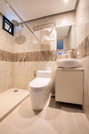 Une salle de bain moderne équipée de toilettes, d’un bidet et d’une douche.