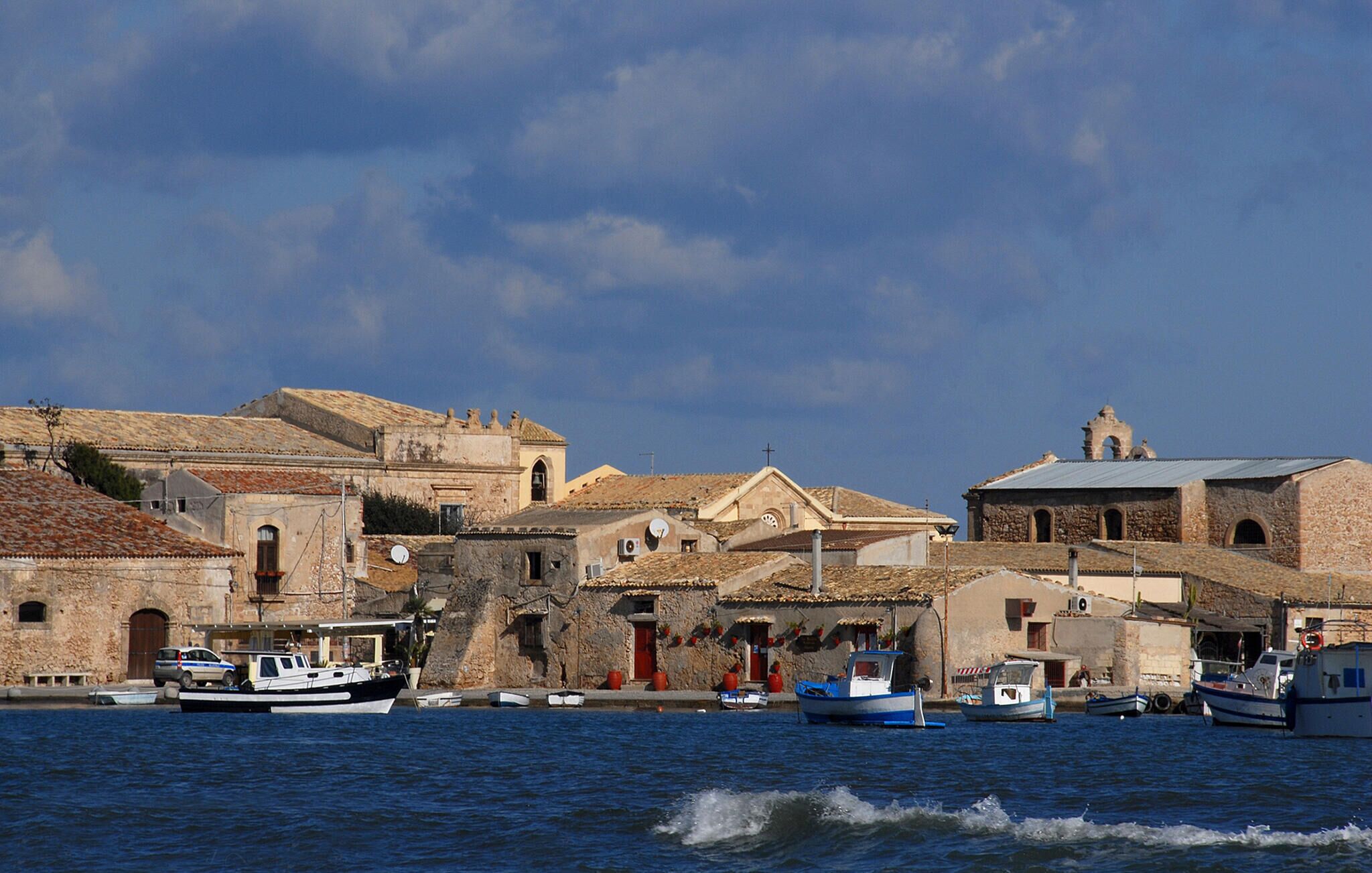 En kystby med historiske bygninger, både i havnen og en klar himmel.