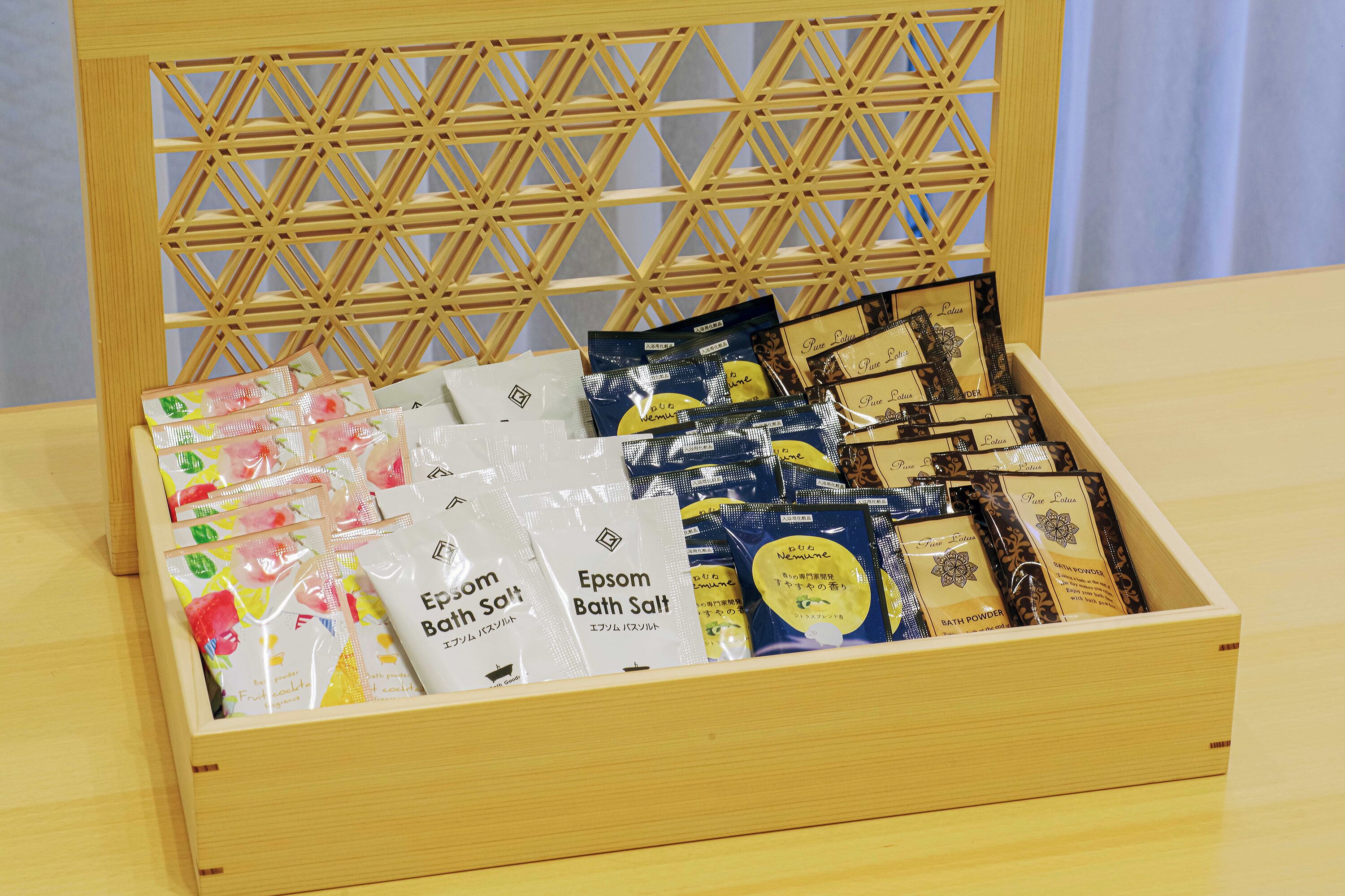 Una caja de madera con compartimentos que contienen diversos productos de baño.