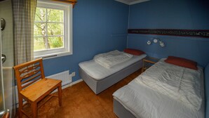 A bedroom with two single beds, a wooden chair, a radiator, and a window with curtains. - Amazing home in Ekshärad with WiFi (Ekshärad)
