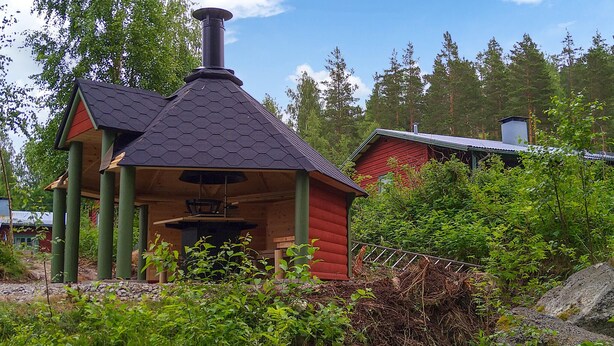 A small wooden cabin with a hexagonal roof and a chimney, surrounded by dense greenery and trees. - Amazing home in Ekshärad with WiFi (Ekshärad)