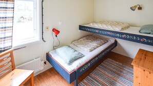A small, compact room with a single bed, a wooden chair, and a small table. - Stunning home in Ekshärad with WiFi (Ekshärad)