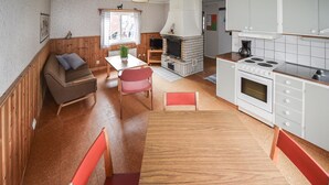 A cozy, compact living space with a kitchenette, a fireplace, a dining area with a table and chairs, and a sofa. - Stunning home in Ekshärad with WiFi (Ekshärad)