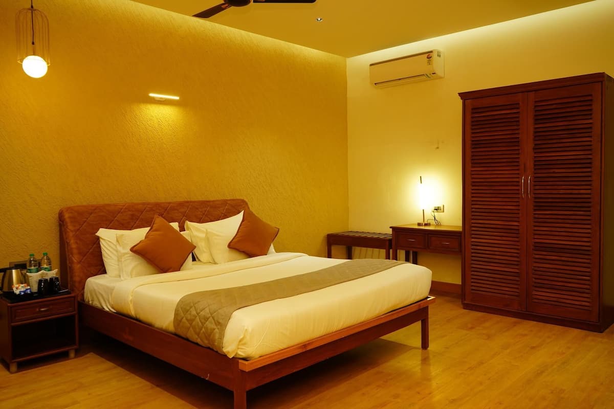 A hotel room with a wooden bed, bedside tables, a wardrobe, and a wall-mounted air conditioner.