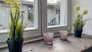 Un rebord de fenêtre orné de plantes en pot et de vases décoratifs.