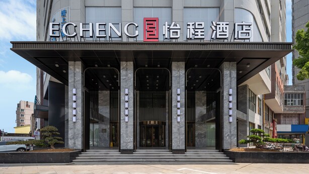 A hotel entrance with a modern facade, large columns, and a prominent sign. - ECHENG Hotel Xiaogan East Station Yintai City (Xiaogan)