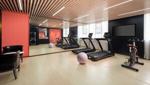 A gym with treadmills, an exercise bike, and a mirror. - ECHENG Hotel Xiaogan East Station Yintai City (Xiaogan)