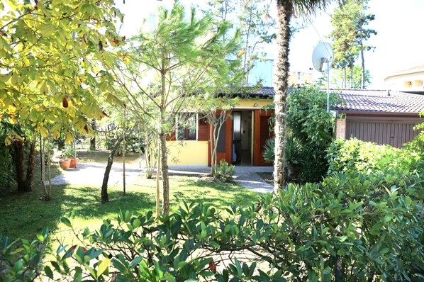 Una propiedad residencial con una casa pequeña, una antena parabólica y un jardín bien cuidado.