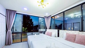 A modern bedroom with two beds, large windows, and a ceiling light fixture. - Emery Pool Villa Pattaya
We are welcome your family,friend and your pet (Banglamung)