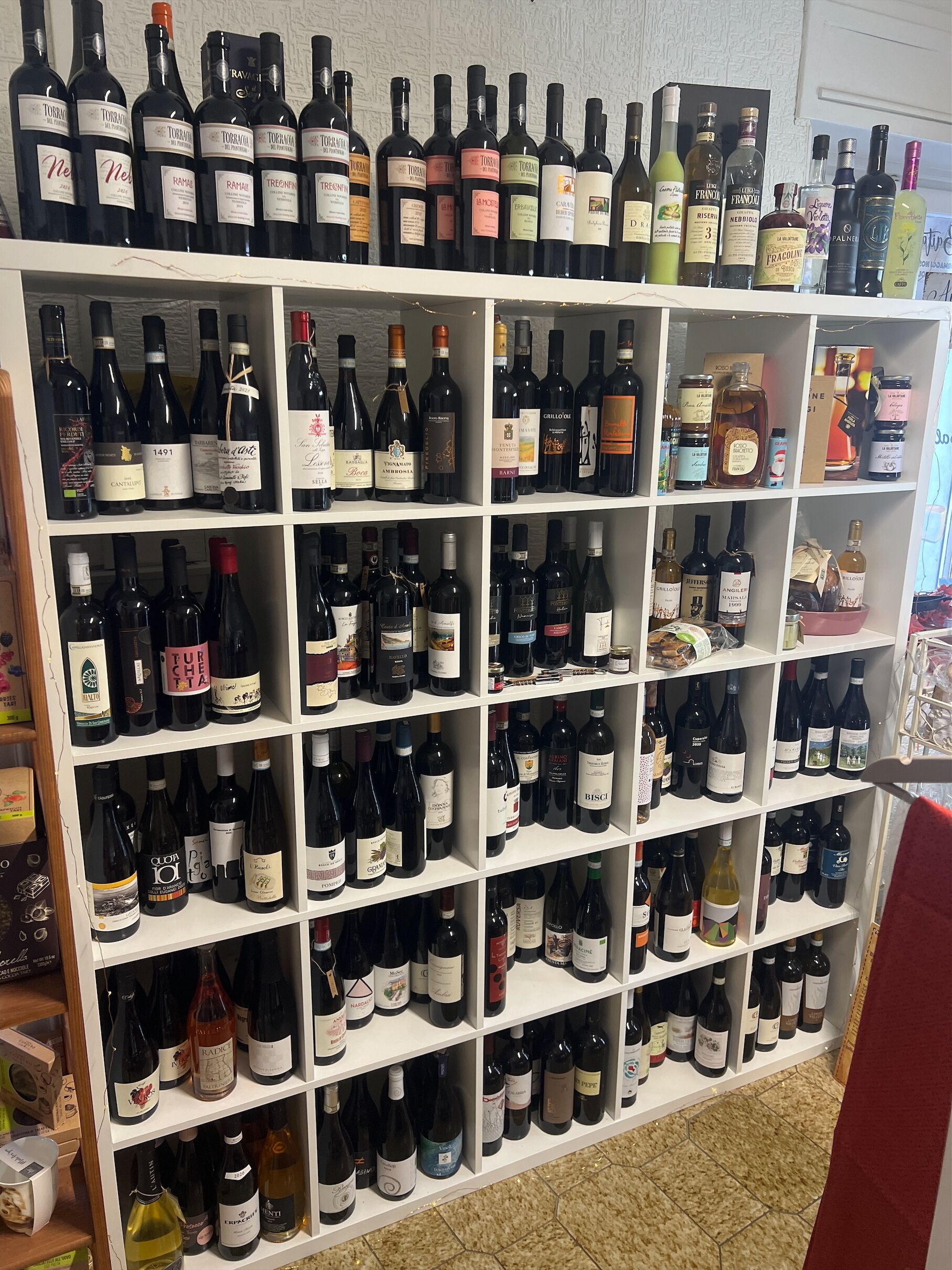 Un meuble à bouteilles contenant différentes sortes de vin.