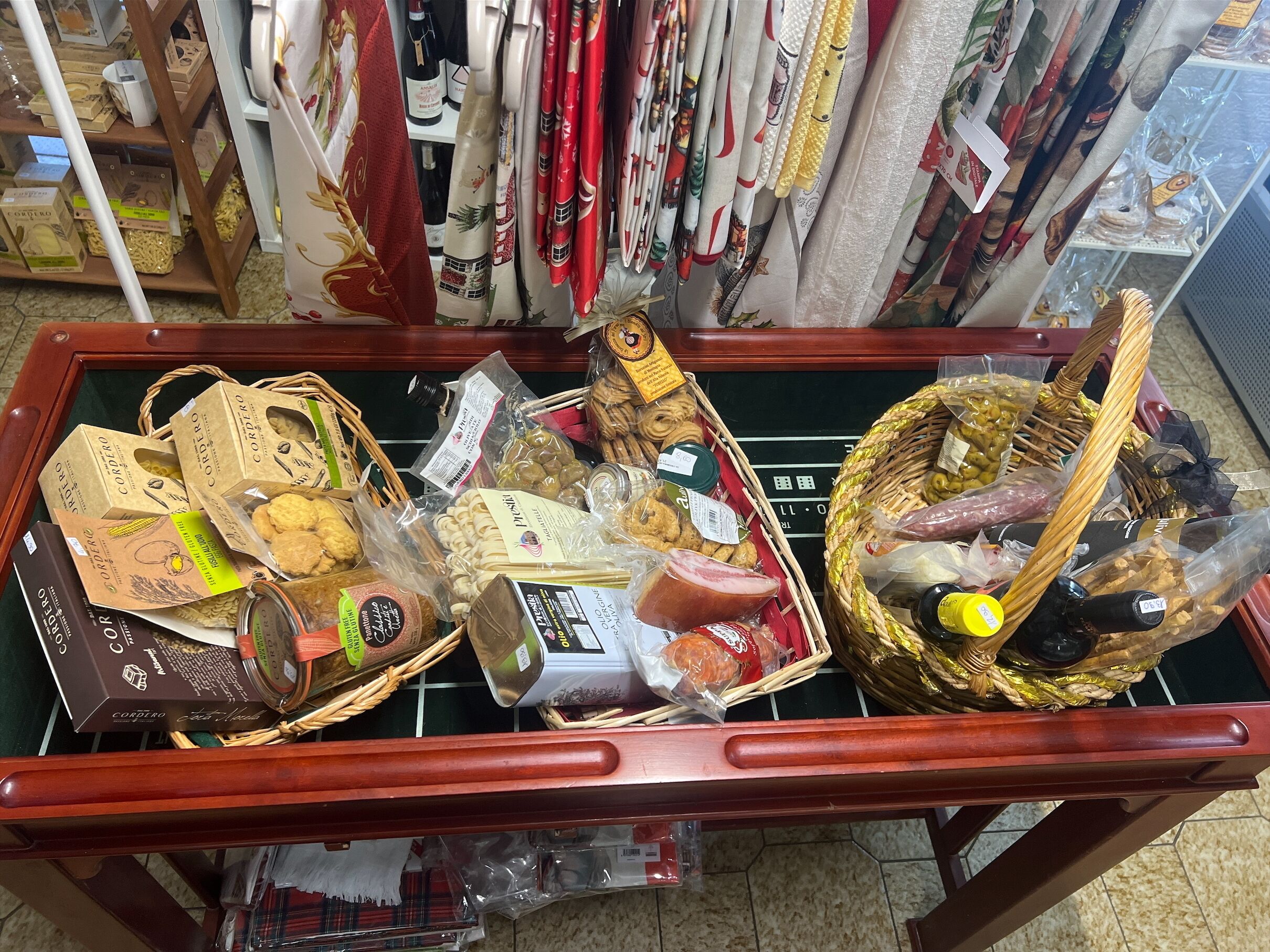 Una exhibición de diversos alimentos y productos envasados sobre una mesa de madera en una tienda.