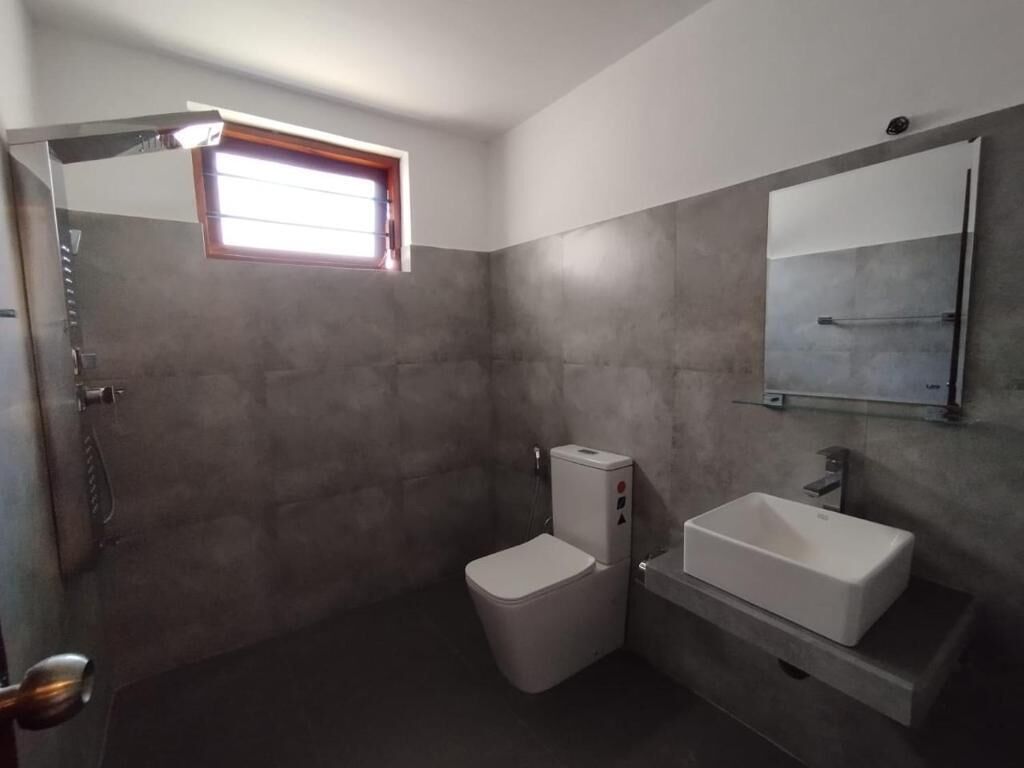 A bathroom with a toilet, a sink, and a shower.