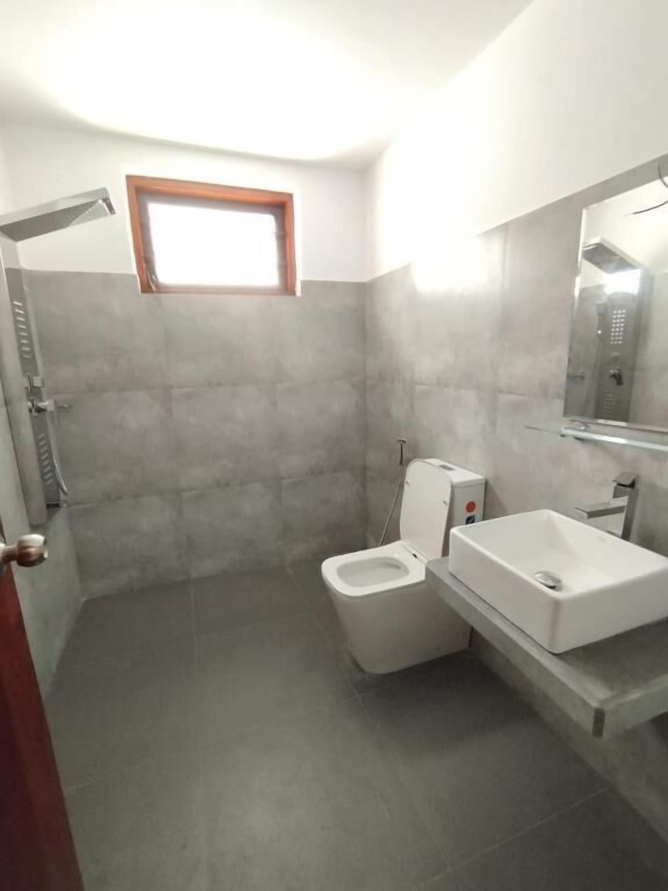 A bathroom with a shower, toilet, and sink.