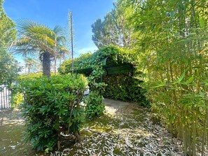 A garden with various plants and a pathway. - DINKY VILLA 237 - B1 4+0 - C02372 (Bibione Pineda)
