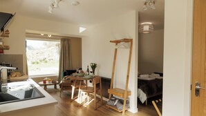 A compact room with a kitchen area, a dining table, and a bed. -  Cosy Cottage with sea view, 10 mins from Portree (Portree)