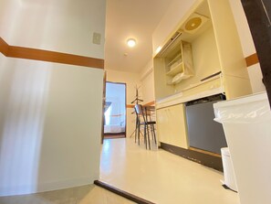 Eine Küche mit weißen Schränken, einem schwarzen Kühlschrank und einer Arbeitsplatte.