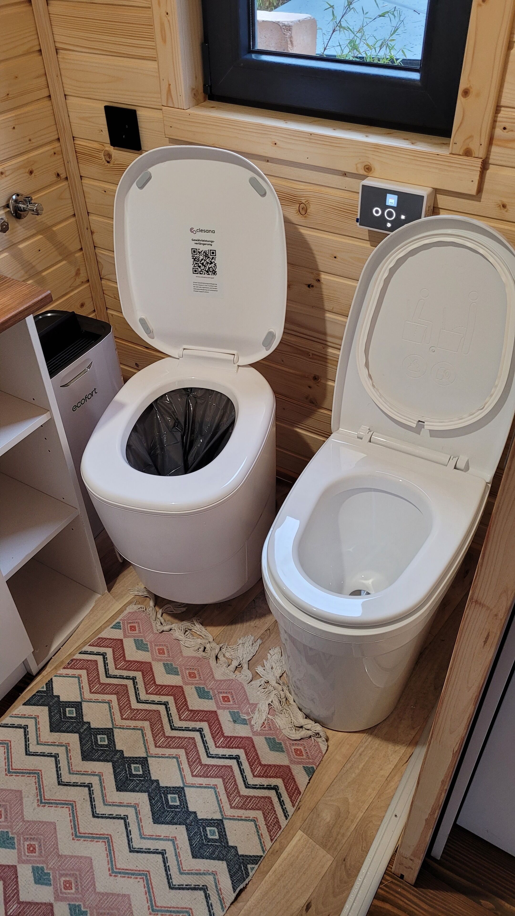 A compact, modern bathroom with a white toilet, a trash bin, and a small shelf unit.