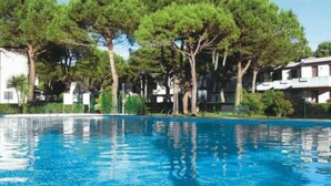 A swimming pool surrounded by trees and buildings. - Calm and green residential house (Bibione)