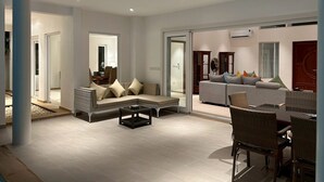 Un amplio espacio de estar con un conjunto de sofás, una mesa de centro y sillones de mimbre.