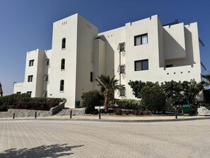 A modern building with a symmetrical facade, multiple windows, and a central staircase. - Fanadir Marina 3-bedroom apartment El Gouna with an amazing Marina view (Red Sea Governorate)