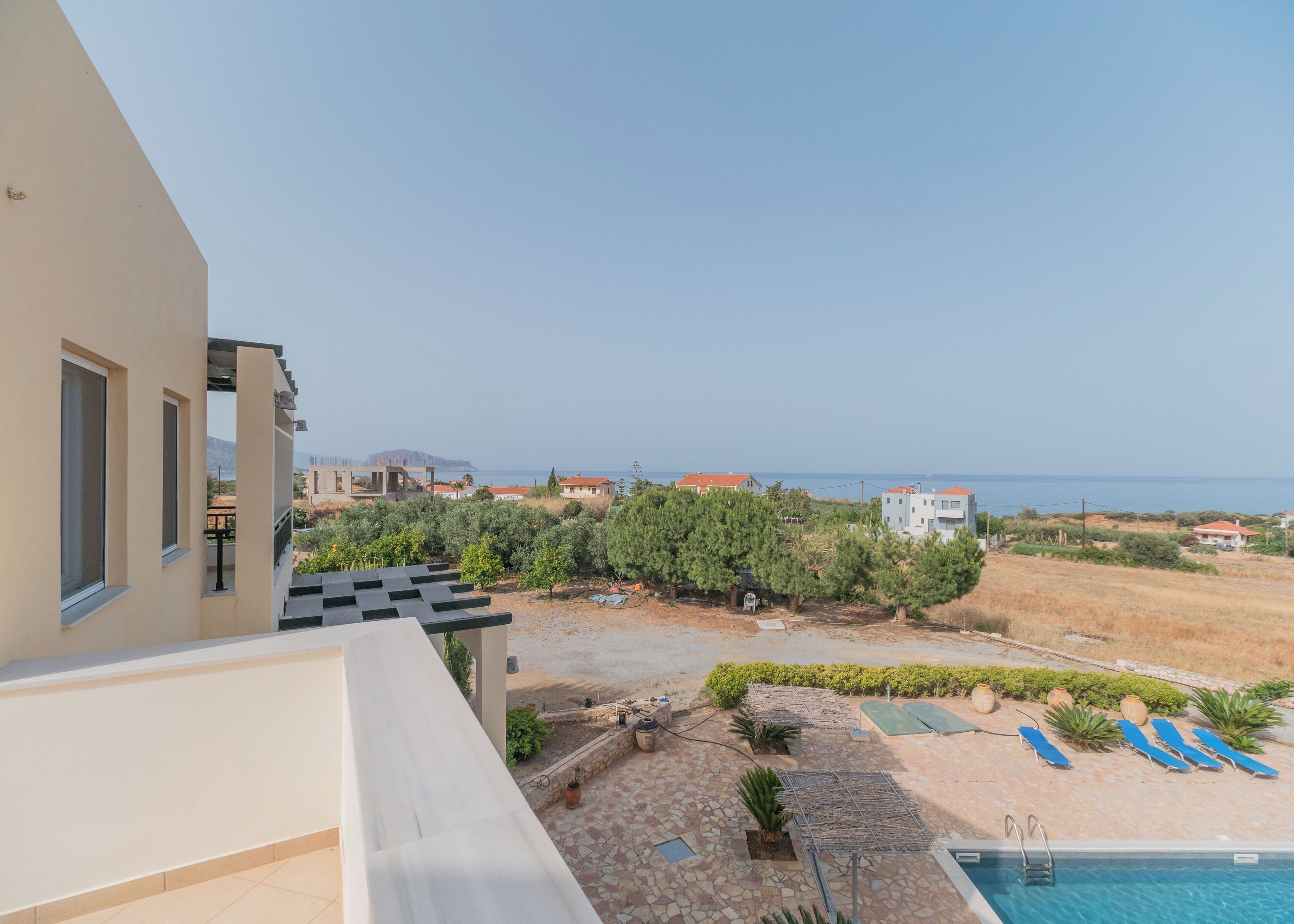 A residential property with a pool, outdoor seating, and a view of the sea.