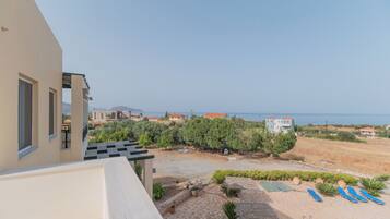 A residential property with a pool, outdoor seating, and a view of the sea.