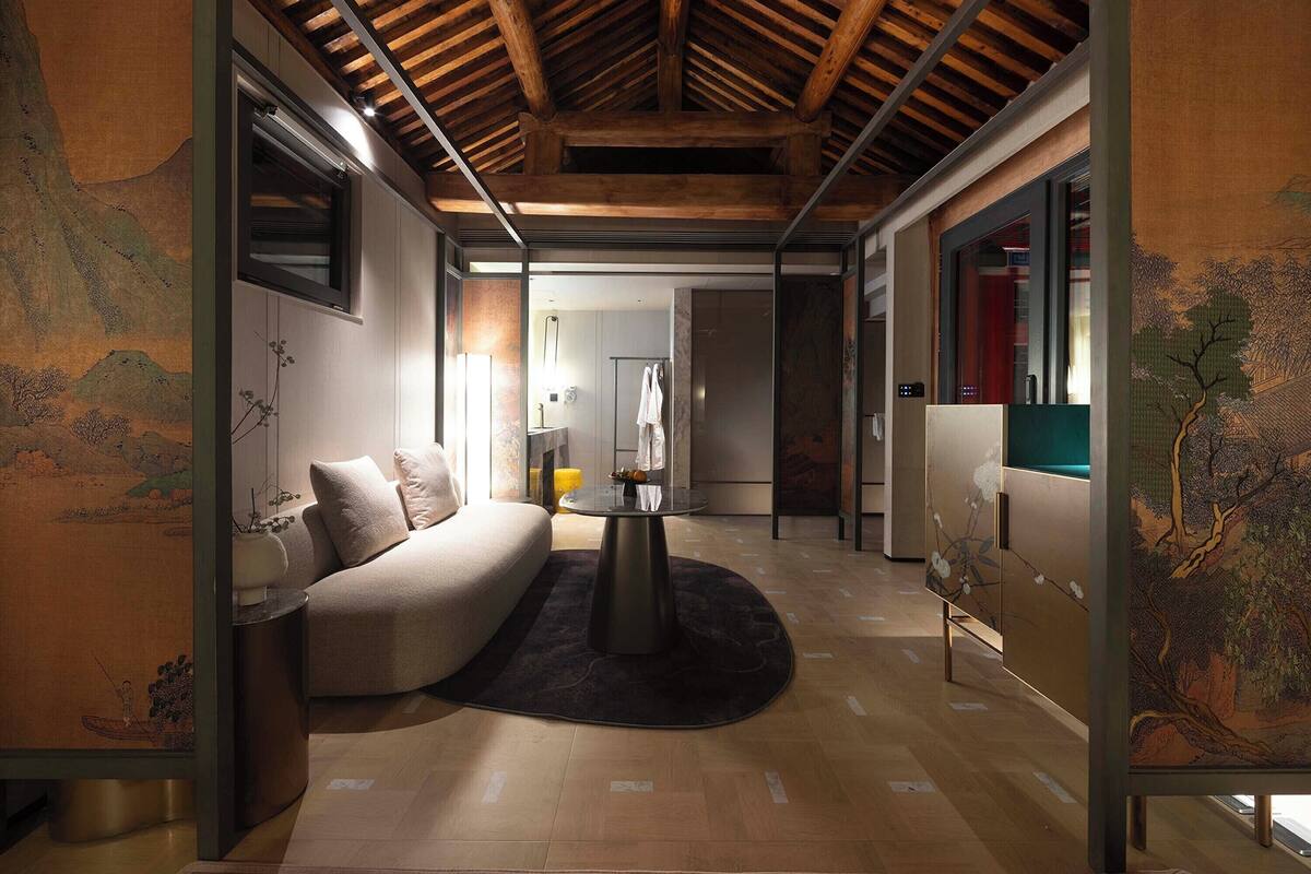 Un interior moderno con techo de madera, un sofá, una mesa redonda y obras de arte en las paredes.