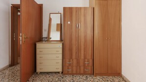 A room with a wooden wardrobe, a dresser, and a mirror. - Faenza Huge Apartment (Firenze)