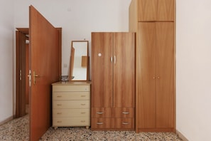 Une pièce comprenant une armoire en bois, une commode et un miroir.