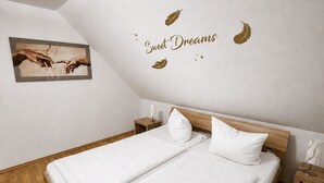 Un dormitorio con dos camas, un mural en el techo y una mesita de noche pequeña.