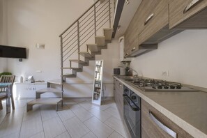 Eine moderne Küche mit einem eingebauten Gasherd, einer Edelstahl-Dunstabzugshaube und einem Holzkorpus.