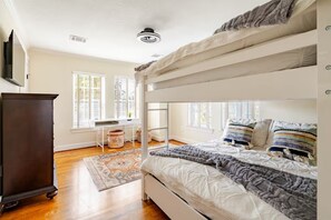 A bunk bed room with a desk, a dresser, and a window with blinds. - Lucky House 2 Tranquility in the Middle of Houston (Houston)