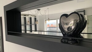 A modern interior with a large mirror reflecting a room with a chandelier and a heart-shaped object on a shelf. - Feel good for 1-4 people at Casa Berg in Spiesen-Elversberg (Spiesen-Elversberg)