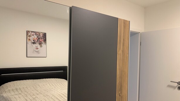 A bedroom with a bed, a wardrobe, and a framed picture on the wall. - Feel good for 1-4 people at Casa Berg in Spiesen-Elversberg (Spiesen-Elversberg)