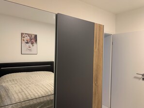 A bedroom with a bed, a wardrobe, and a framed picture on the wall. - Wellness for 1–4 people at Casa Berg in Spiesen-Elversberg (Spiesen-Elversberg)