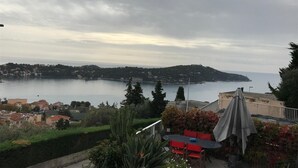 Terraço com mesa e cadeiras com vista para a costa.