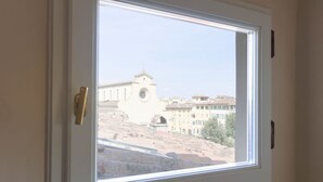 Ein Fenster mit Blick auf ein Gebäude mit einem Glockenturm.