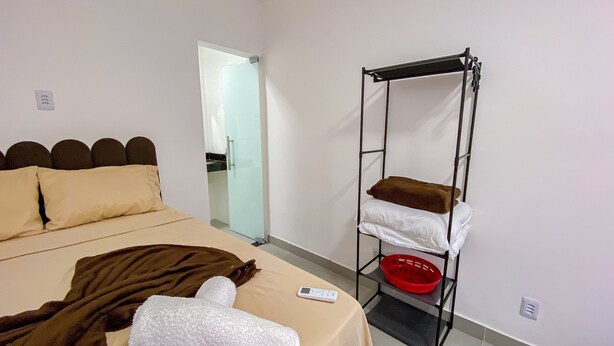Quarto com cama, mesa de cabeceira, armário e porta.