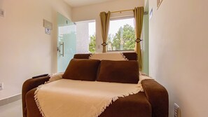 A room with a bed, a window with curtains, a door, and a WiFi sign. - Condomíno American Praia  (Porto Seguro)