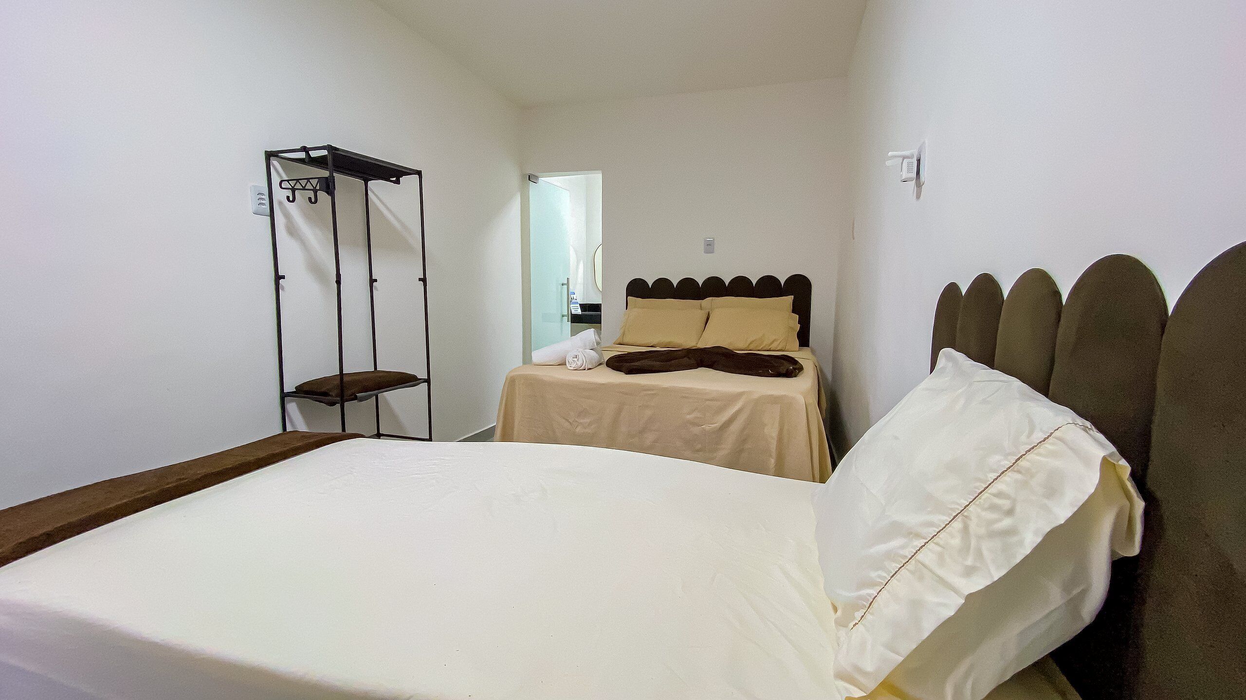 A small, neatly arranged bedroom with a single bed, a nightstand, and a wardrobe.