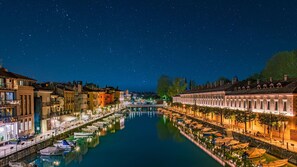 A canal lined with historic buildings, a bridge, and boats. - SG Family - Casa di Manu (Peschiera del Garda)